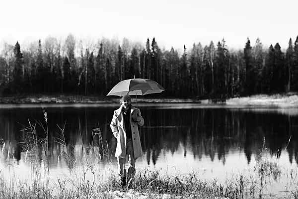 winter walk with an umbrella / man in a coat with an umbrella, walk against the backdrop of the winter landscape, winter view