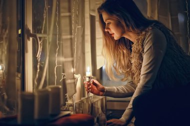 Noel akşamı kız / güzel genç yetişkin modeli, rüyalar ve yılbaşı gecesi mumlar de dilek yapar