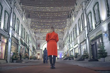 Şehirde kış gecesi. Işıklar. Paltolu yetişkin bir kız. Şehirde yürüyüş.