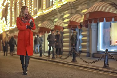 Şehirde kış gecesi. Işıklar. Paltolu yetişkin bir kız. Şehirde yürüyüş.