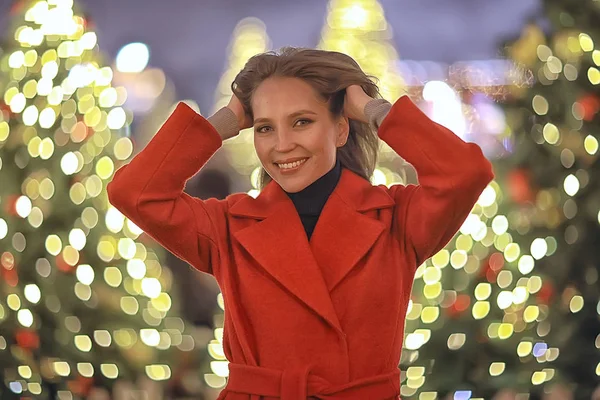 街でクリスマスウォーク 大人の女の子はお祝いの夜に夜の街を歩く 街のライトは新年です — ストック写真