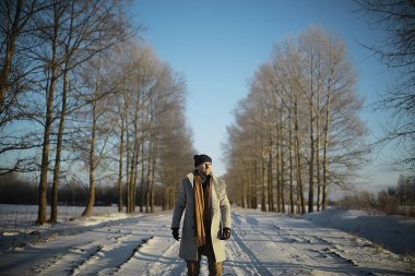 bir ceket / kış tarzı moda adam, kış manzara, karlı hava, sıcak giysilerin fon karşı yürümek