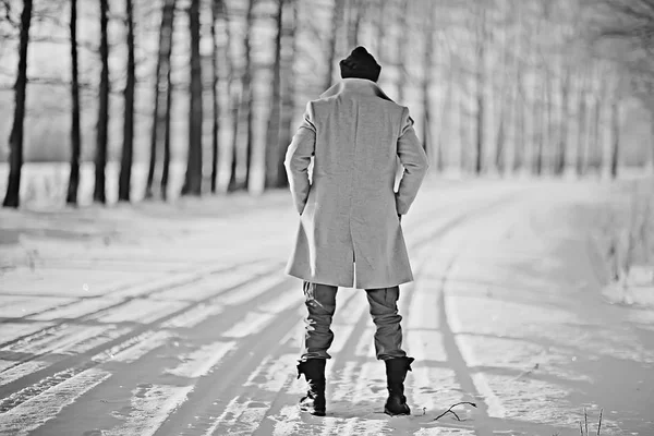 コート 冬のスタイルでファッショナブルな男は 冬の風景 雪の天候 暖かい服を背景に歩きます — ストック写真