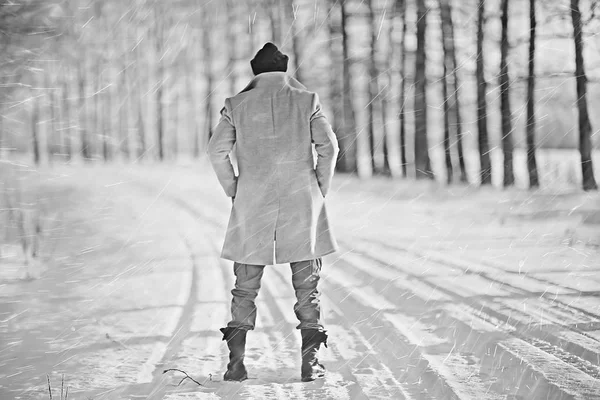 コート 冬のスタイルでファッショナブルな男は 冬の風景 雪の天候 暖かい服を背景に歩きます — ストック写真