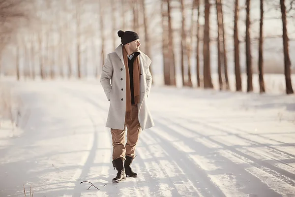 コート 冬のスタイルでファッショナブルな男は 冬の風景 雪の天候 暖かい服を背景に歩きます — ストック写真