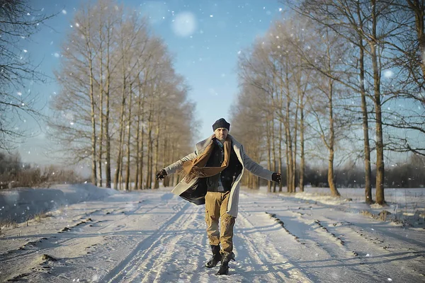 コート 冬のスタイルでファッショナブルな男は 冬の風景 雪の天候 暖かい服を背景に歩きます — ストック写真