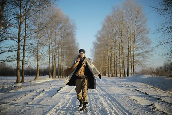 コート 冬のスタイルでファッショナブルな男は 冬の風景 雪の天候 暖かい服を背景に歩きます — ストック写真