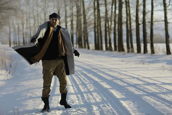 コート 冬のスタイルでファッショナブルな男は 冬の風景 雪の天候 暖かい服を背景に歩きます — ストック写真