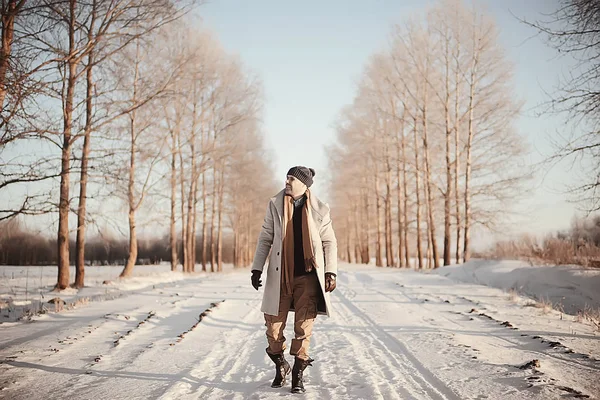 コート 冬のスタイルでファッショナブルな男は 冬の風景 雪の天候 暖かい服を背景に歩きます — ストック写真