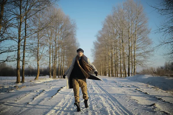 コート 冬のスタイルでファッショナブルな男は 冬の風景 雪の天候 暖かい服を背景に歩きます — ストック写真