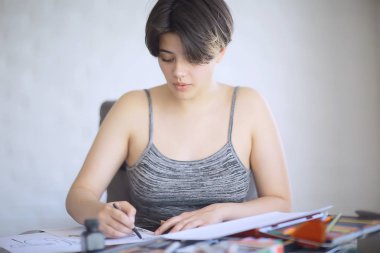 yetişkin kız kağıt kalem / güzel bir genç kız öğrencinin portresi, sanat okulu eğitimi, sanat eğitimi kavramı üzerine çizer
