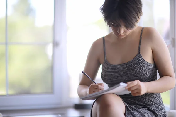 adult girl draws on paper pencils / portrait of a beautiful young female student, art school education, concept of art education