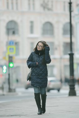 şehirde bir kış yürüyüşü bir ceket yetişkin model kız / Noel tatil şehir turu