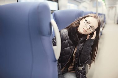 kız bir tren / kış taşıma oturur, bir yetişkin kız seyahat tren penceresinin yanında oturur