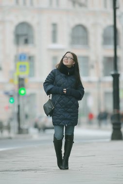 şehirde bir kış yürüyüşü bir ceket yetişkin model kız / Noel tatil şehir turu