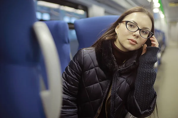 女の子は電車に座る 冬の輸送 1人の大人の女の子は 列車の窓の側に座って旅行 — ストック写真