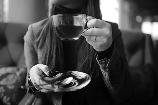 girl in a cafe drinking tea / a modern cafe, a young adult model drinking tea and holding a cup in her hand