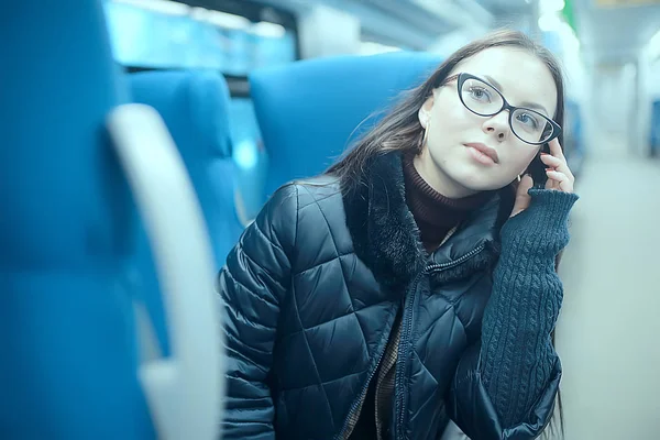女の子は電車に座る 冬の輸送 1人の大人の女の子は 列車の窓の側に座って旅行 — ストック写真