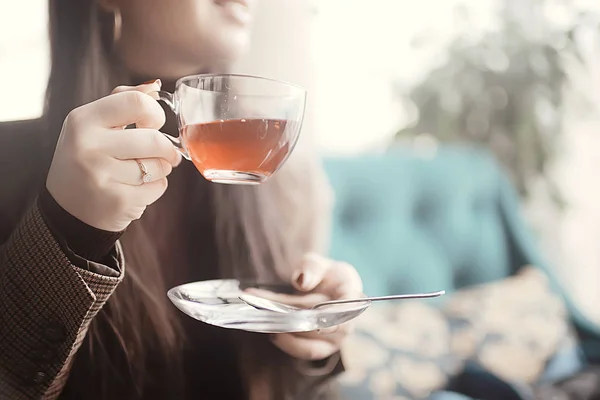 girl in a cafe drinking tea / a modern cafe, a young adult model drinking tea and holding a cup in her hand