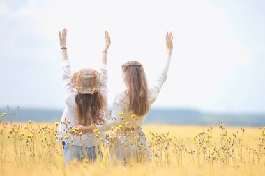 bir sonbahar alanında mutluluk iki kız arkadaş / iki genç kadın bir alanda sarılma, mutluluk dostluk
