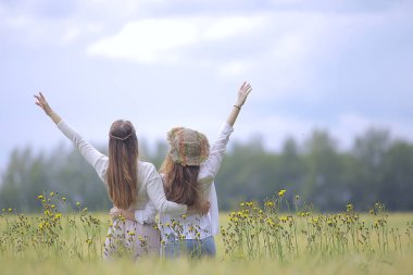 bir sonbahar alanında mutluluk iki kız arkadaş / iki genç kadın bir alanda sarılma, mutluluk dostluk