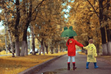 çocuk erkek ve kız kardeş oyun sonbahar yağmur / Ekim hava küçük çocuklar şehirde yürümek
