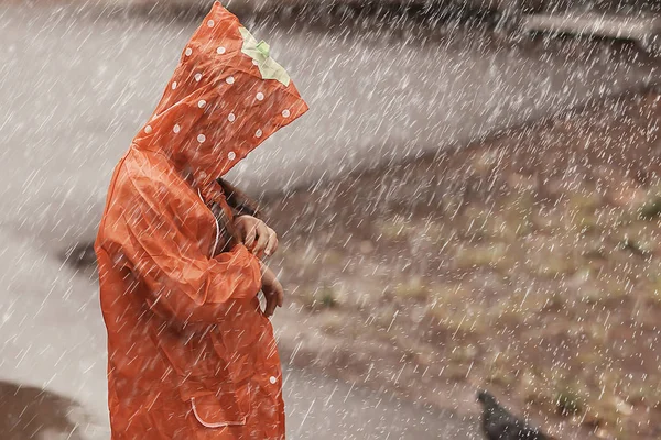 レインコートを着た子供は雨の中で外で遊ぶ 季節の写真 秋の天気 子供のための暖かい服 — ストック写真