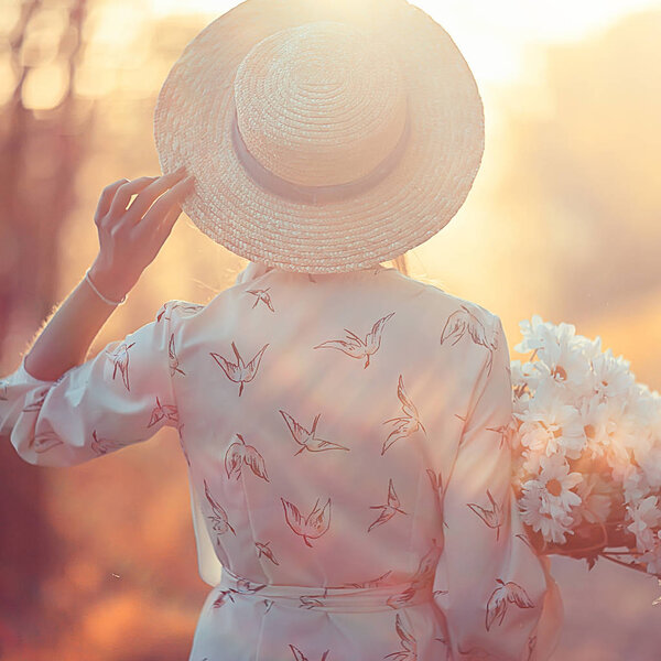 romantic girl in a straw hat view from the back / model girl poses in the summer, tourist happiness