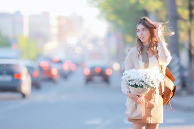 şehirde çiçek ile mutlu kız / yaz fotoğraf genç güzel kız bir şehir sokakta çiçek bir buket tutan
