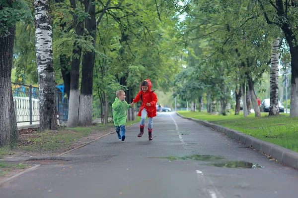 黄色い秋の公園の雨で走る子供たち 楽しい散歩秋の風景天気 — ストック写真