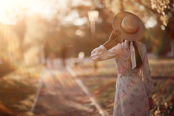 romantic girl in a straw hat view from the back / model girl poses in the summer, tourist happiness