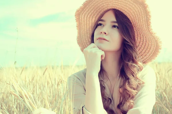 麦わら帽子 夏休み 若い大人の幸せな女性を休ませるフィールドに座っている女の子 — ストック写真