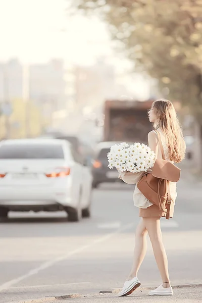 花束を持つ女の子がストリートカーを歩く 都市の景色 花を持つモデルの若い女の子との風景 — ストック写真