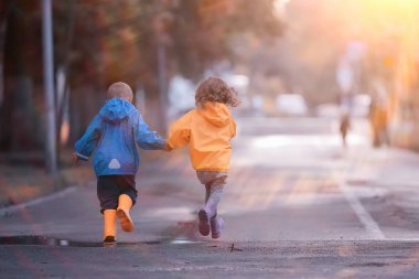 çocuklar sarı sonbahar parkı yağmur / eğlenceli yürüyüş sonbahar mevsimlik manzara ıslak koşmak
