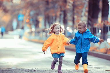 çocuklar sarı sonbahar parkı yağmur / eğlenceli yürüyüş sonbahar mevsimlik manzara ıslak koşmak
