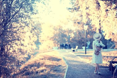 şehir manzarasında yürüyen bir buket çiçek ile mutlu kız / bir şehir tarih / mutlu kız bekliyor, yumuşak ışık