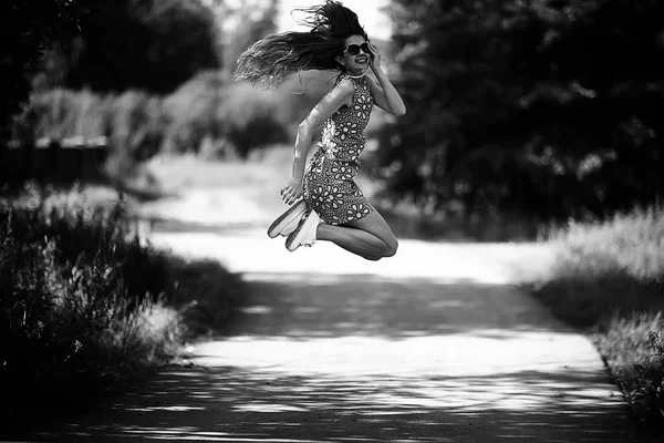 俏皮的成年年轻女孩在夏天漩涡跳跃 欢快美丽的模型在公园 夏天看在短裙 — 图库照片