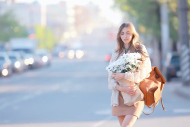 şehirde çiçek ile mutlu kız / yaz fotoğraf genç güzel kız bir şehir sokakta çiçek bir buket tutan
