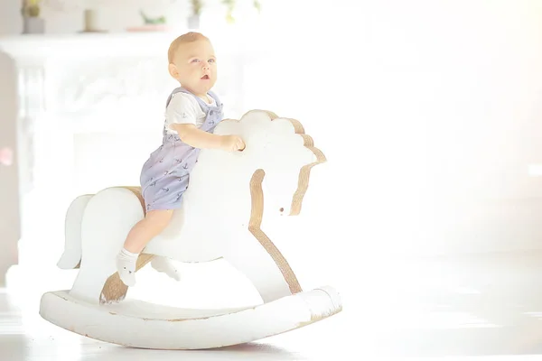 子供ロッキング馬 おもちゃの馬に乗って小さな男の子 ロッキングチェア子供のおもちゃのヴィンテージ — ストック写真