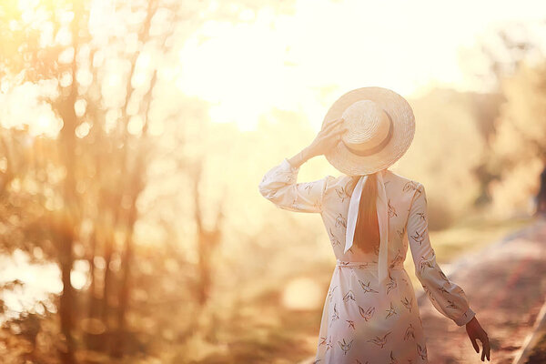 romantic girl in a straw hat view from the back / model girl poses in the summer, tourist happiness