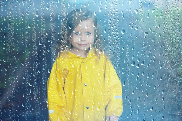 レインコートを着た子供は雨の中で外で遊ぶ 季節の写真 秋の天気 子供のための暖かい服 — ストック写真