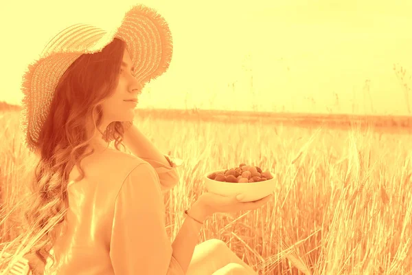 ピクニックフィールドの太陽を食べる女の子のラズベリー 晴れた夏のフィールドでラズベリーを食べる大人の若いモデル 幸せロマンスを楽しむ — ストック写真