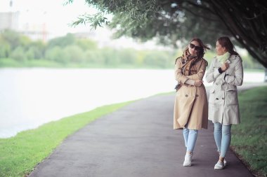 sonbahar moda parkı kız iki bakmak / bir ceket iki göz alıcı moda kız bir şehir parkı yürümek