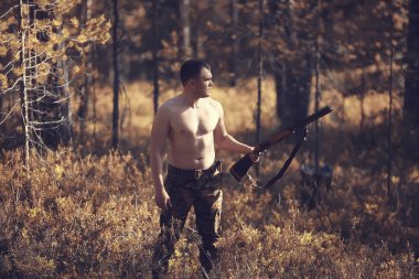 sonbahar ormanlarında bir silah avcılık ile avcılık adam / avcı, taiga sarı ağaçlar manzara