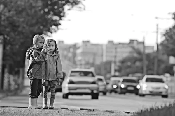 children cross the road / boy and girl small children in the city at the crossroads, car, transport