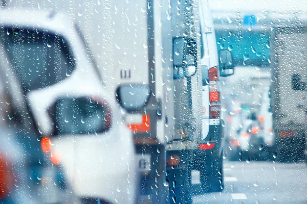 drops on glass auto road rain autumn night / abstract autumn background in the city, auto traffic, romantic trip by car