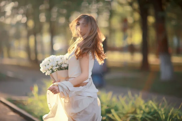 街の花を持つ幸せな女の子 夏の写真若い美しい女の子は 街の通りに花の花束を持っています — ストック写真