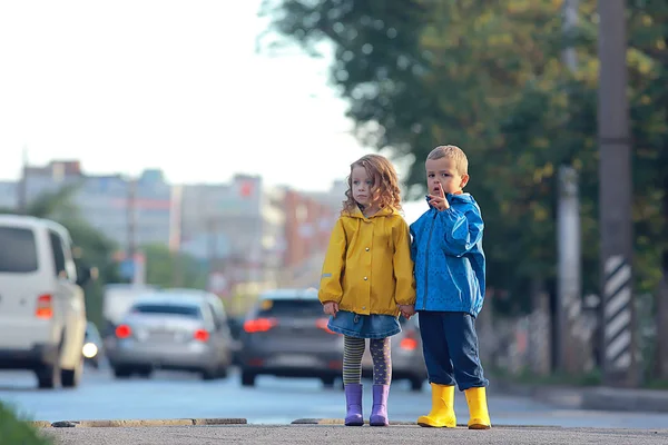 children cross the road / boy and girl small children in the city at the crossroads, car, transport