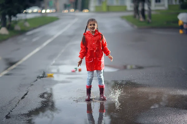 ゴムブーツの女の子水たまり 概念天気 子供のための暖かい服 — ストック写真