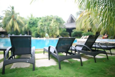 otel şezlong havuzu / tropikal otelde dinlenme, rahat dinlenme, rekreasyon